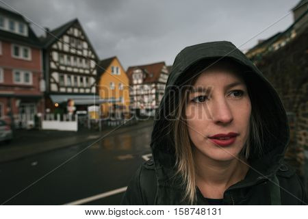 Young woman outdoor portrait, rainy day in small rown