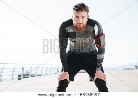 Tired runner near the sea. looking at camera. front view