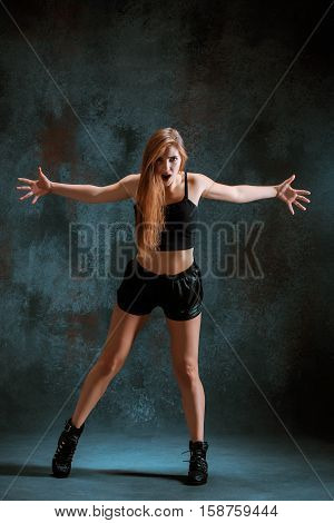 Attractive girl dancing twerk iat the blue studio background