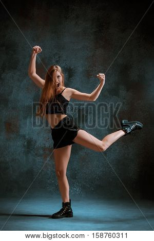 Attractive girl dancing twerk iat the blue studio background