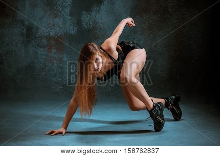 Attractive girl dancing twerk iat the blue studio background