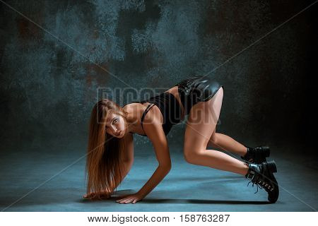 Attractive girl dancing twerk iat the blue studio background