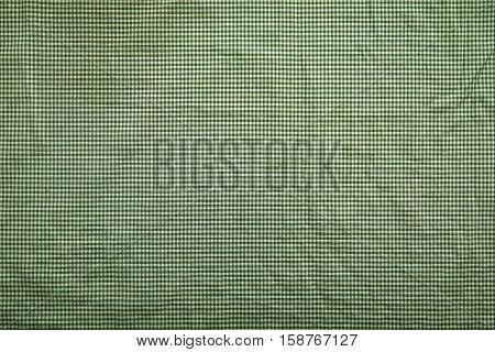Background image with slightly wrinkled green and white traditional checkered tablecloth