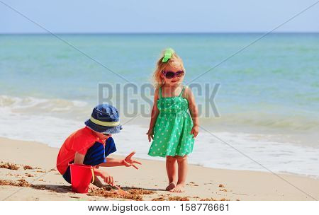 kids play with sand on summer tropical beach, family beach vacation