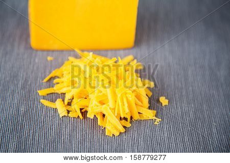 Grated  yellow cheese on a grey background