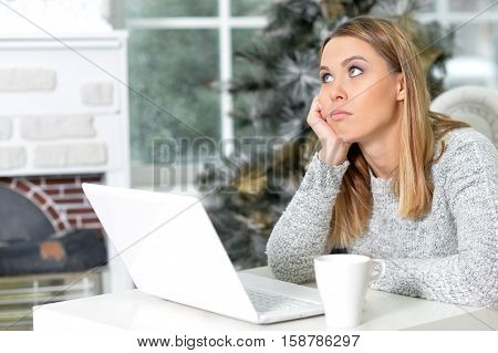 Portrait of thoughtful young woman with laptop