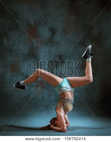 Attractive girl dancing twerk iat the blue studio background