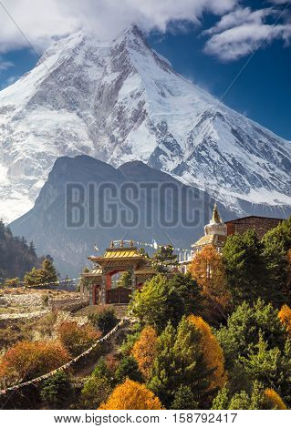 Traditional Buddhist monastery and Manaslu mount in Himalayas, Nepal.  Autumn, view from Manaslu circuit trek