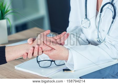 Female patient at orthopedic medical exam in doctor's hospital office traumatology and medical consultation for hand wrist injury