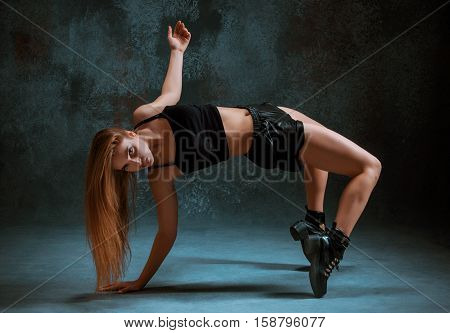 Attractive girl dancing twerk iat the blue studio background
