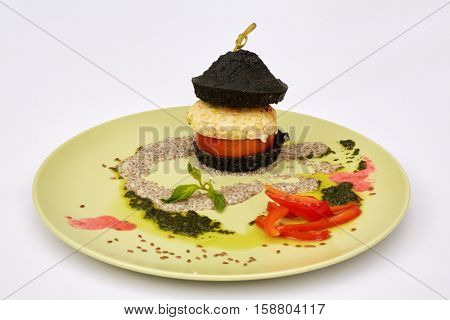 Ground-meat cutlet with vegetables and sauce on plate.