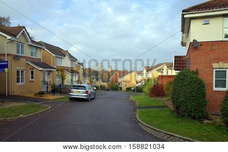 Bracknell,England - November 23, 2016: Homes on a modern housing estate with parked cars and a church bell tower in the distance in Bracknell, England