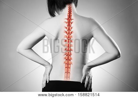 Spine pain woman with backache and ache in the neck black and white photo with red backbone on gray background