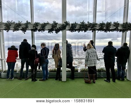 LONDON - NOVEMBER 27: People observing up to 40 miles away across the urban sprawl below from the outdoor gallery on level 72 of The View from The Shard on November 27, 2016 in London, UK.