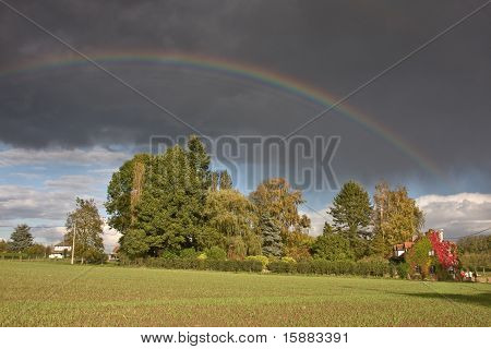Regenbogen und Regen über einem Körper