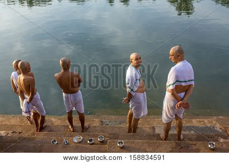 Gokarna, India - January 16, 2016: Unidentified hindu piligrims standing on the bank of the sacred lake in Gokarna. The city is a holy pilgrimage site for Hinduists