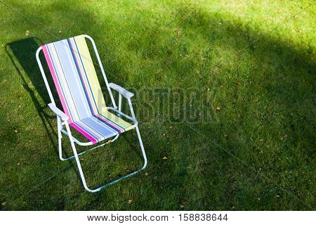 garden chair on green lawn background