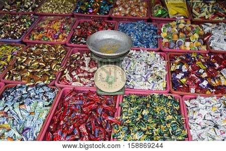 Hanoi, Vietnam - Nov 26, 2016: Many kind of candies of many local Vietnamese brands with a balance for whole sale and retail on the side walk of Hang Buom old quarter street.