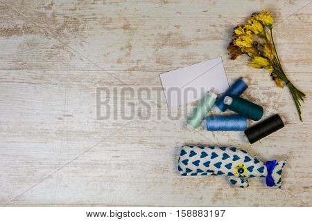 Fashion design inspiration. Colored thread and hand-made toys on vintage wooden backgroundtop view.
