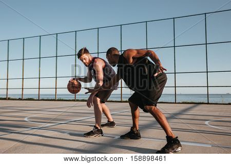 Two healthy basketball players at the playground outdoors