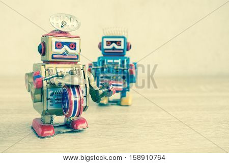 Old robot toy on wood table, vintage color style, vintage tone background.