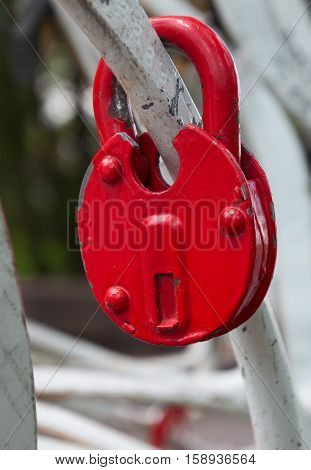 Red iron lock on a white fence close-up