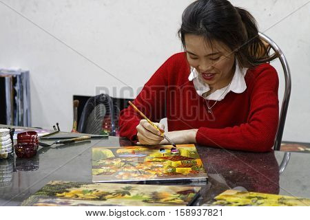 HANOI VIETNAM October 30 2016 : Unidentified artist paints in a workshop of lacquer of Hanoi. Lacquerware are objects decoratively covered with lacquer mostly from East Asian cultures.