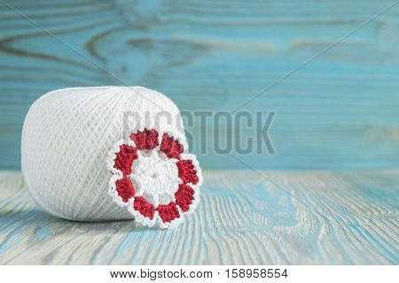 White ball of eco natural cotton yarn for knitting crochet knitted leaves. Rustic wooden background Irish crochet lace pattern elements