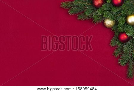 Corner Christmas fir branch with Christmas balls on a red background with the wishes of Merry Christmas 2017