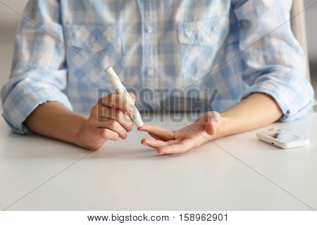 Woman using lancelet on finger