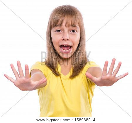 Half-length emotional portrait of caucasian girl wearing yellow t-shirt. Funny cute child looking at camera with her hands in frightening gesture, isolated on white background.