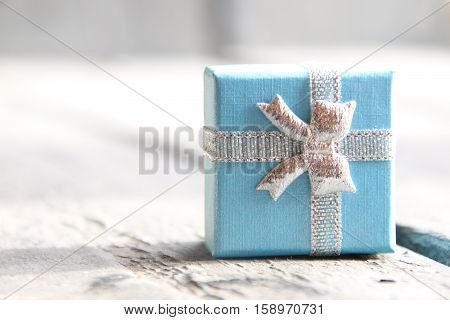 Gift box with ribbon on vintage wooden background