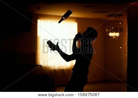 Barman show. Bartender pours alcoholic cocktails. Black silhouette