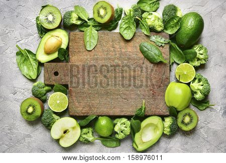 Variety Of Green Fruits And Vegetables With Empty Wooden Cutting Board.top View.