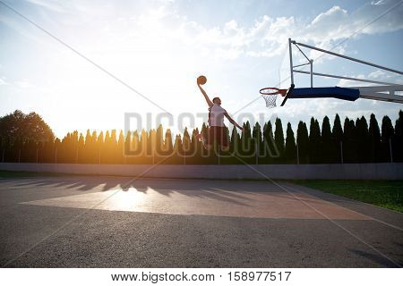 Young Man Jumping And Making A Fantastic Slam Dunk Playing Stree