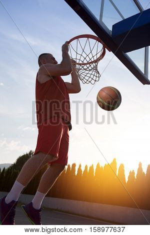 Young Man Jumping And Making A Fantastic Slam Dunk Playing Stree