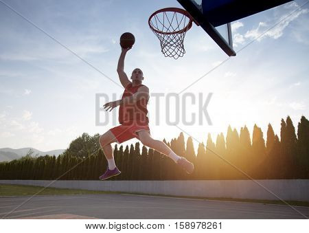 Young Man Jumping And Making A Fantastic Slam Dunk Playing Stree