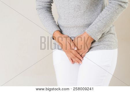 Young Woman Having Painful Stomachache With Hands Holding Pressing Her Crotch Lower Abdomen. Medical