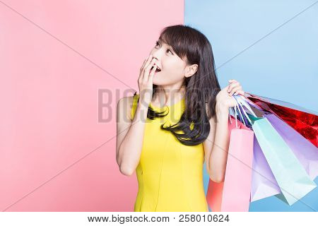 Woman Feel Surprise And Take Shopping Bag Happily On The Blue And Pink Background