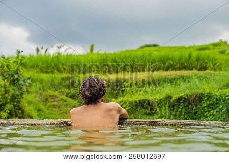 Man Tourist In Belulang Hot Springs In Bali On The Background Of Rice Terraces