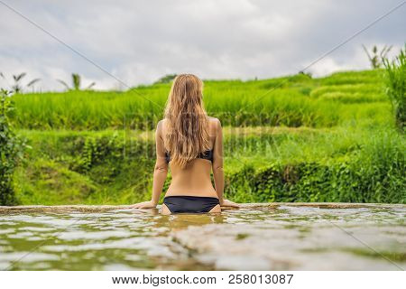 Young Woman Tourist In Belulang Hot Springs In Bali On The Background Of Rice Terraces