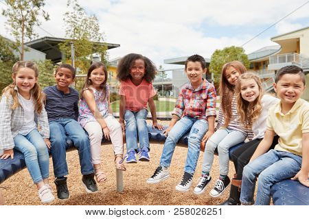 Elementary school kids sitting on carousel in the schoolyard