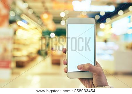 Hand Of Female Customer Using Mobile Application When Shopping In Supermarker