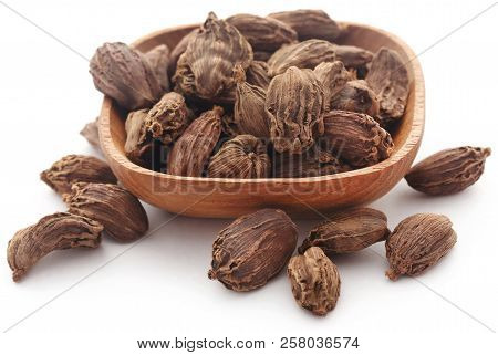 Black Cardamom In A Bowl Over White Backgroumd