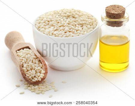 Peeled Sesame Seeds With Oil In Bottle Over White Background