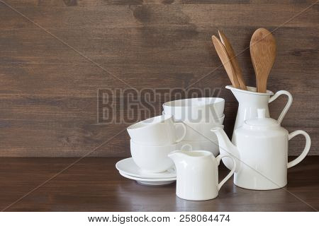 Crockery, Clayware, White Utensils And Other Different Stuff On Wooden Tabletop. Kitchen Still Life 