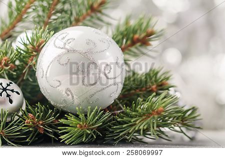 Silver Christmas Background Of Defocused Bokeh Lights With Decorated Fir Tree Branches