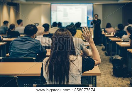 Speaker On The Stage With Rear View Of Audience In Put Hand Up Acton For Question In The Meeting Or 