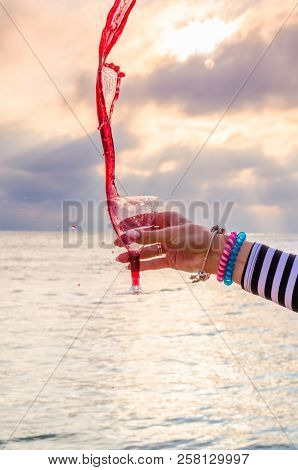 Girl Holding A Glass With Wine Uring The Sunset On The Sea