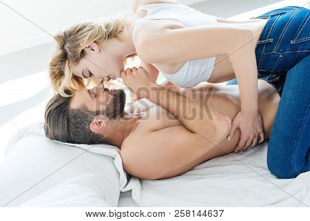 Side View Of Passionate Young Couple Able To Kiss In Bed